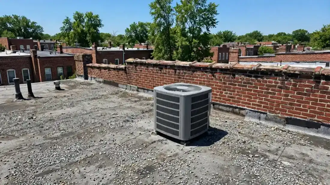 Outdoor condenser on a rowhouse rooftop under bright sun